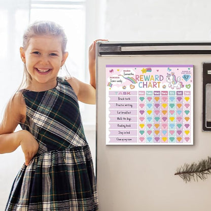 Child holding a unicorn reward chart displayed on a fridge-style magnetic surface