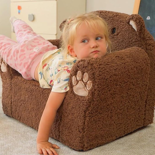 Brown bear toddler sofa chair with plush arms and child resting on seat
