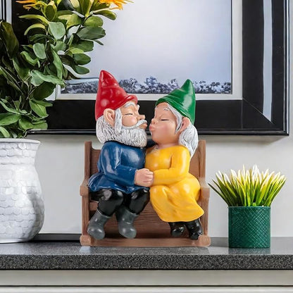 Garden gnome couple rocking chair statue on ledge, kissing, red and green hats, blue and yellow