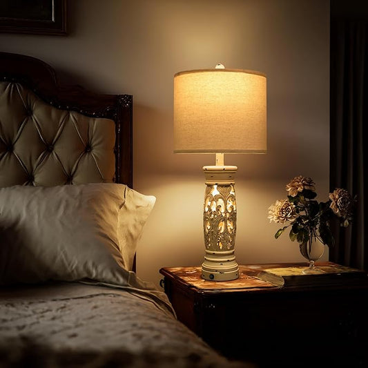 Farmhouse bedside table lamp with beige shade and ornate white carved base