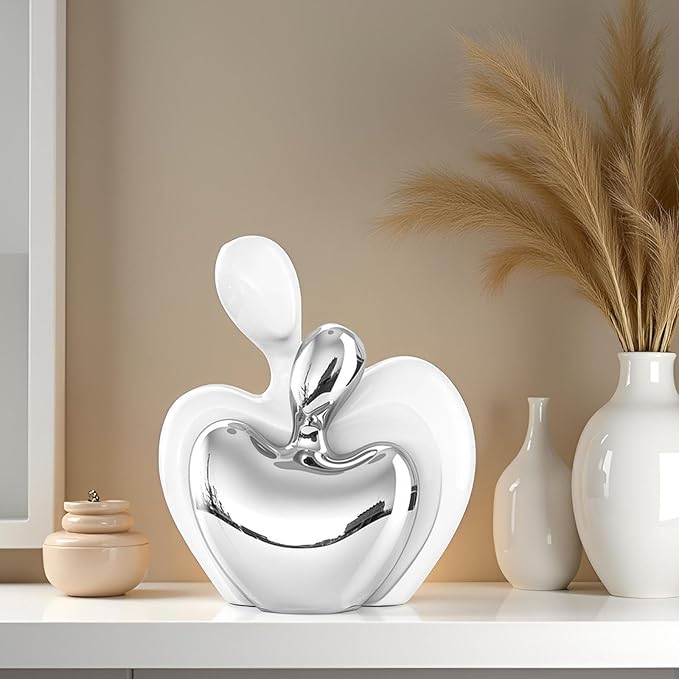 White ceramic and silver couple figurine, glossy hugging heart shape for display.