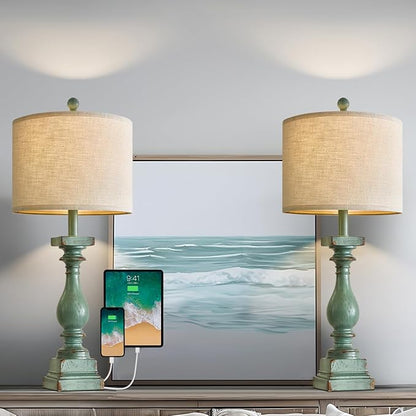 Pair of green table lamps with beige drum shades on console table