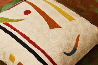 Cream pillow cover close-up with orange, yellow, red, and black diagonal stripes