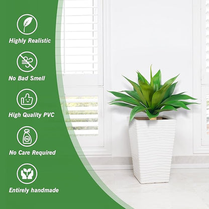 Green faux agave plant in white planter beside a window