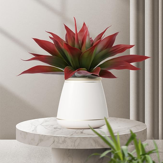 Wine-red faux agave plant with green centers in white planter on round table