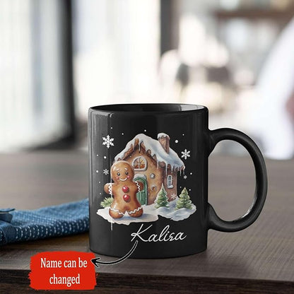 Black ceramic mug with gingerbread house design, “Kalisa” name on front.