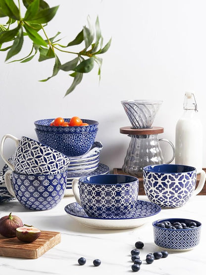 Set of blue-and-white patterned ceramic coffee mugs with handles, styled on tabletop.