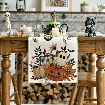 Beige Halloween table runner featuring pumpkin, ghost, bats, and autumn leaves