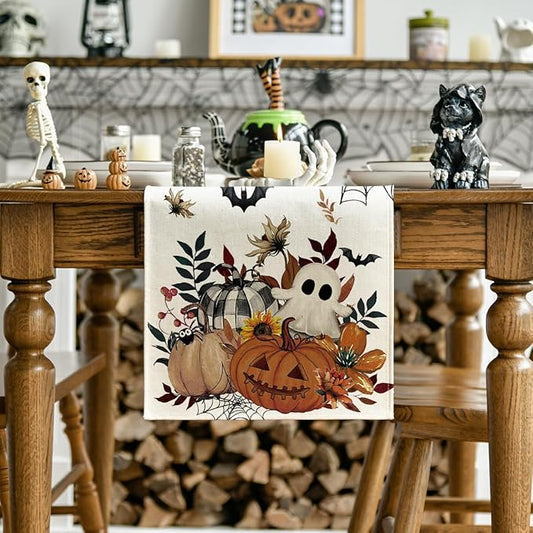 Beige Halloween table runner featuring pumpkin, ghost, bats, and autumn leaves