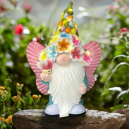 Solar gnome statue with pink butterfly wings, floral crown, and warm LED lights glowing