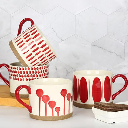 Hand-painted ceramic mugs set with red designs, white bodies, and red handles