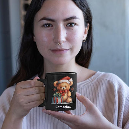 Black mug with teddy bear Santa hat and name 'samantha' held up for display