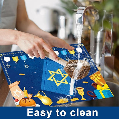 Hands cleaning a blue Hanukkah plastic placemat with “Light it up” center