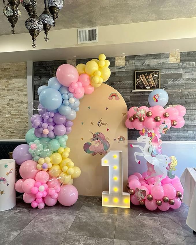 Pastel rainbow balloon arch garland with pink, blue, lavender, and yellow balloon clusters