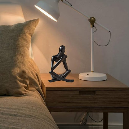Black resin seated reading abstract figurine, side profile