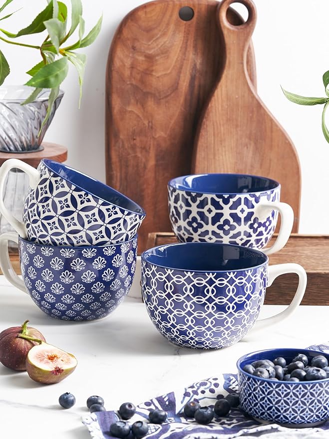 Blue-and-white patterned ceramic coffee mugs with handles, arranged with other kitchen items.