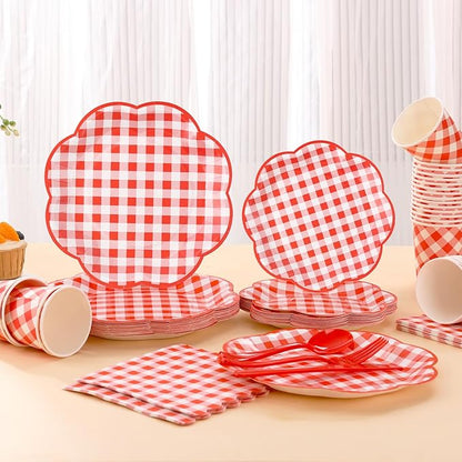 Red and white gingham picnic tableware set with stacked plates, cups, napkins, and cutlery