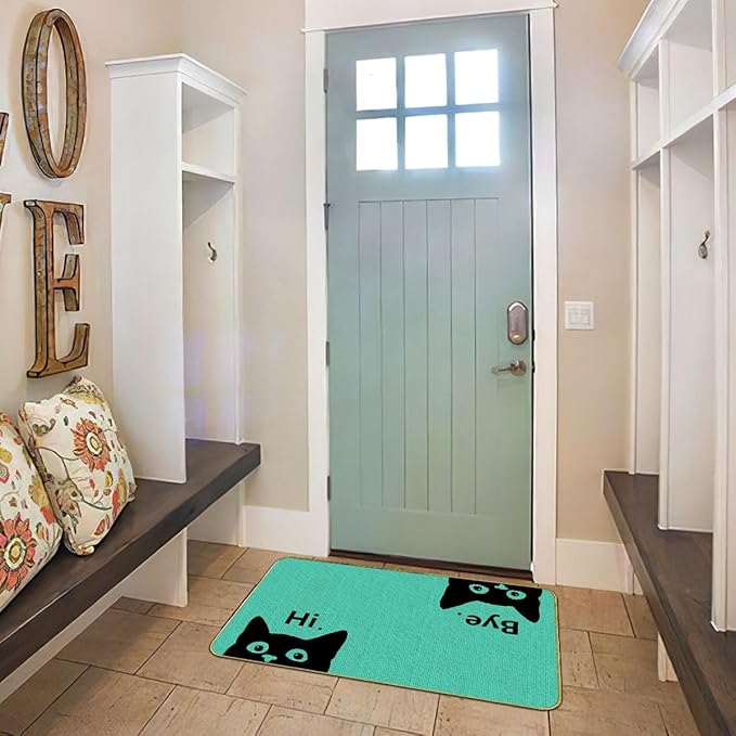 Green cat welcome doormat on indoor entry floor, black cat faces and “Hi”