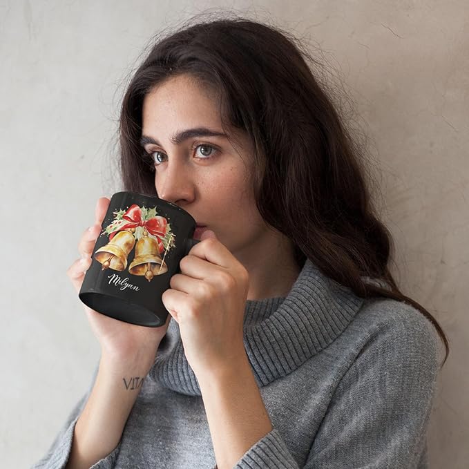 Black ceramic mug with bell and bow print, Milyan script, sipped from