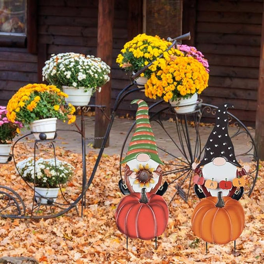Pair of metal garden gnome stake decorations with pumpkin bodies and striped hats for fall