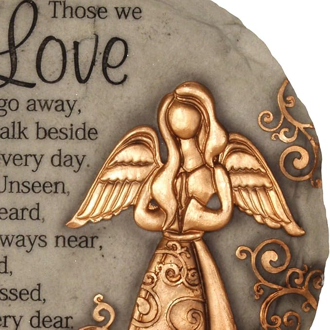Close-up of a bronze angel and scrollwork on a round memorial garden stone