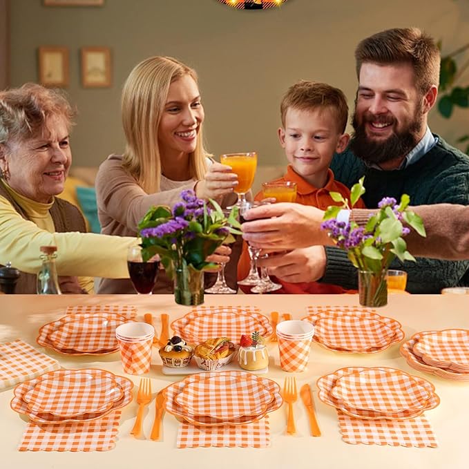 Orange and white gingham party table setting with plates, cups, and cutlery