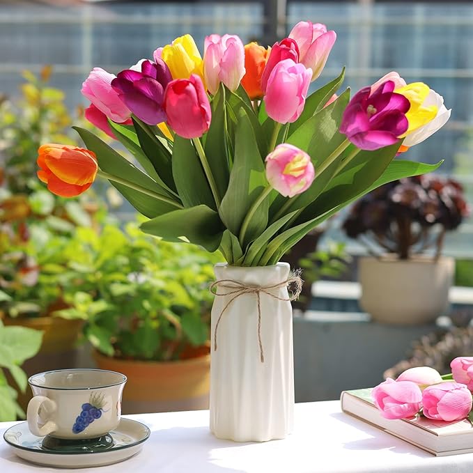 Artificial tulip bouquet with multicolor blooms in white vase on outdoor patio table