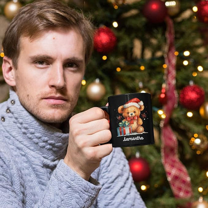Black mug with teddy bear Santa hat design and name 'samantha' held in hand