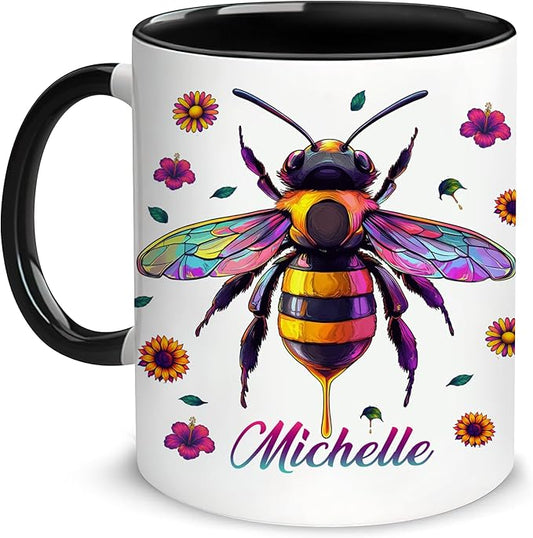 Ceramic coffee mug with colorful bee illustration and 'Michelle' text, black handle