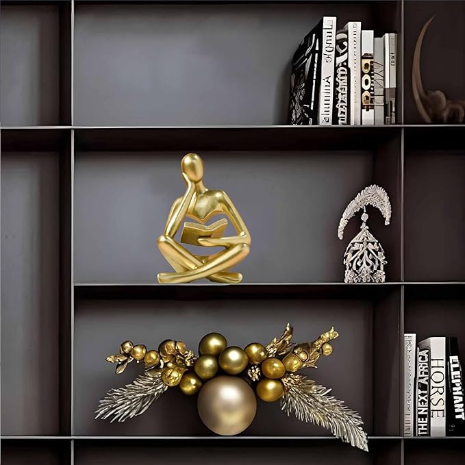 Gold resin seated thinker figurine holding an open book
