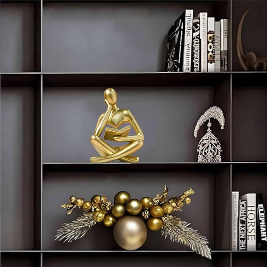 Gold resin seated thinker figurine holding an open book
