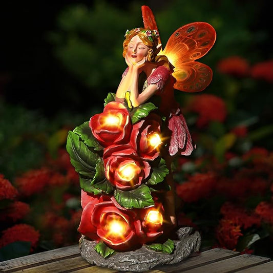 Solar fairy garden statue holding glowing red roses, butterfly wings, standing on a base