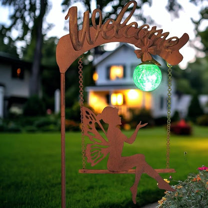 Solar fairy garden light with rust stake, fairy cutout, and glowing green sphere in garden