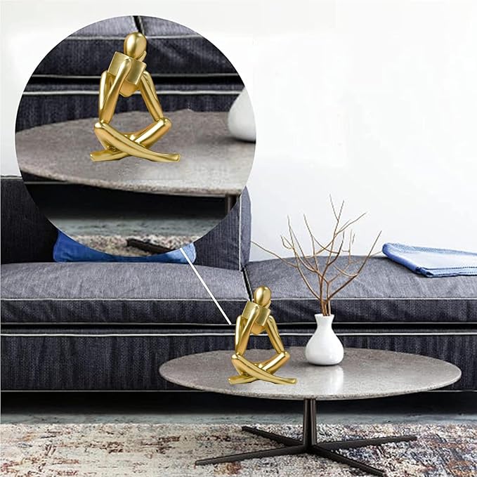 Gold resin reading figurine centered on round side table, seated cross-legged