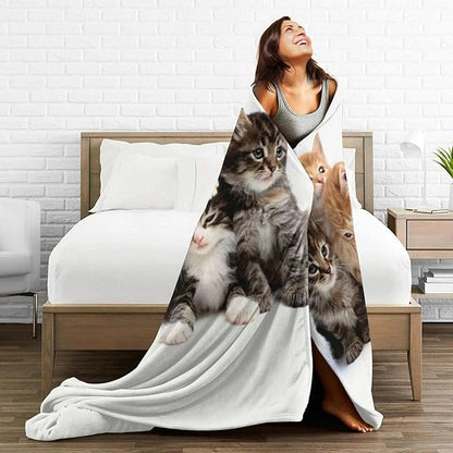 Cats throw blanket draped on a bed, white fleece with a group of kittens print