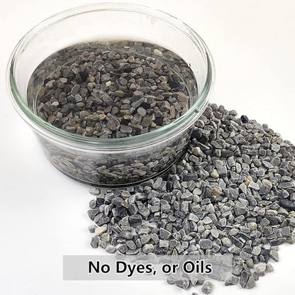 Gray polished pebbles in a clear jar and a loose gravel pile