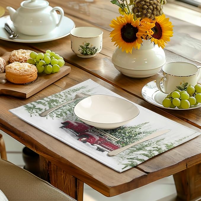 Christmas placemat on dining table under white plate; red truck and pine tree print