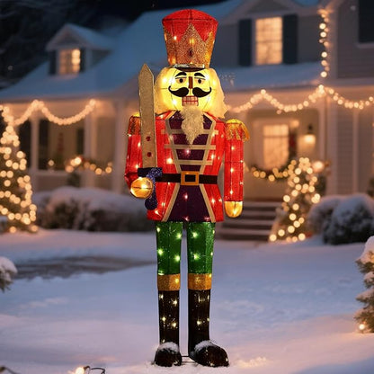 Colorful lighted nutcracker yard stake with red coat, green pants, and glowing LED details