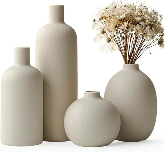 Set of four beige matte ceramic vases, varying heights, with dried stems in one vase
