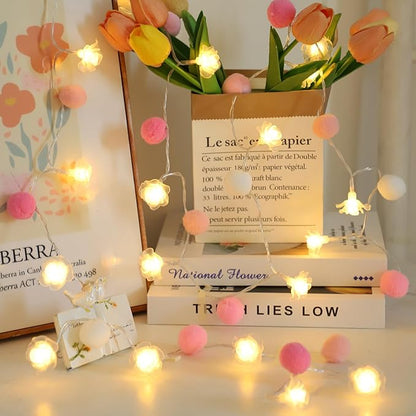 Battery string lights with pink pom-pom balls and warm rose-shaped LED bulbs