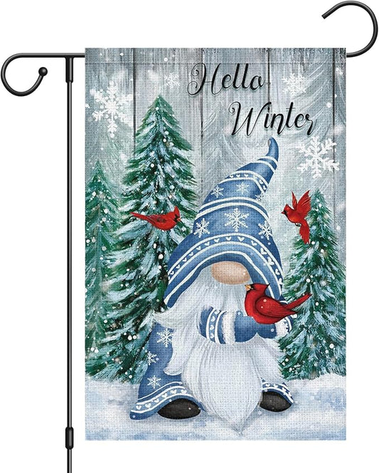 Winter garden flag on pole with snowman, red cardinals, and evergreen trees in snow