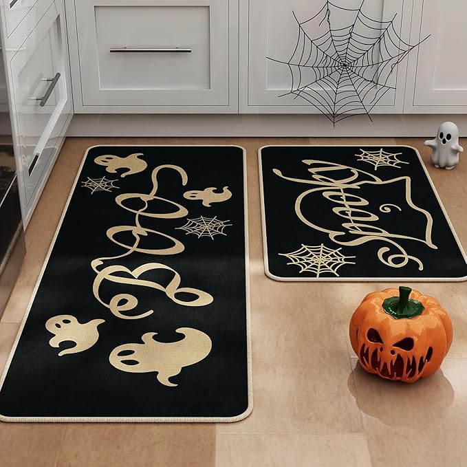 Two black Halloween kitchen rugs with gold ghost and spider web patterns