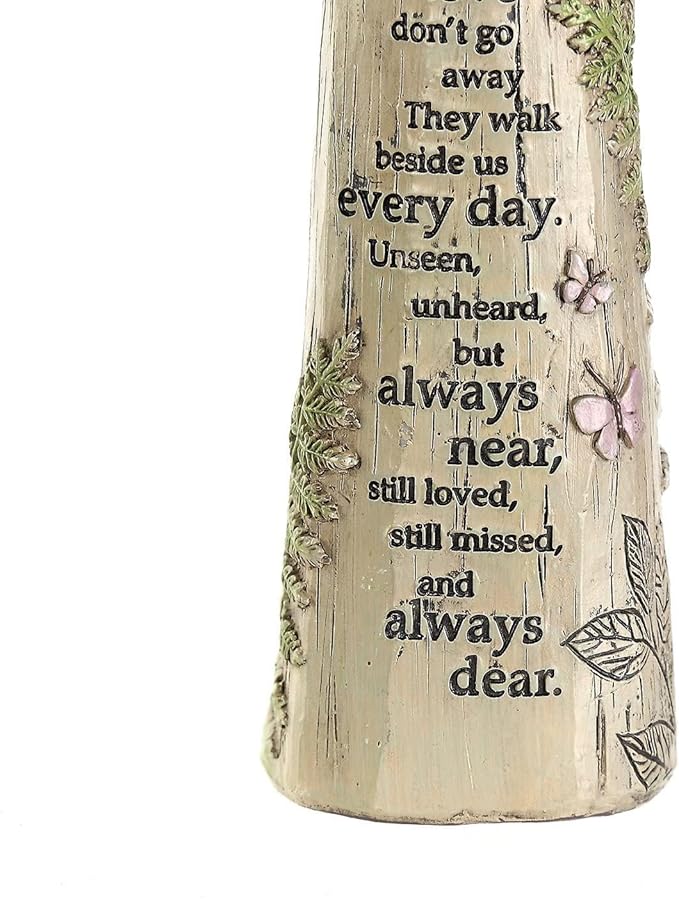 Close-up of the angel figurine's engraved memorial poem and floral butterfly details.
