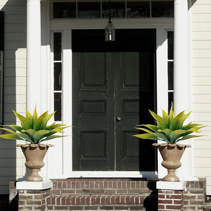 Two faux agave plants with yellow-green leaves in decorative urn planters