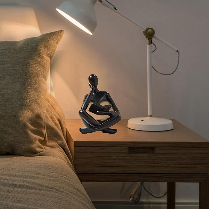 Zuo Si black resin reading thinker figurine on bedside table, seated with crossed legs