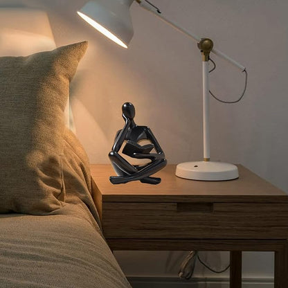 Zuo Si black resin reading thinker figurine on bedside table, seated with crossed legs