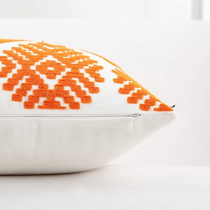 Orange embroidered throw pillow cover corner with white geometric pattern