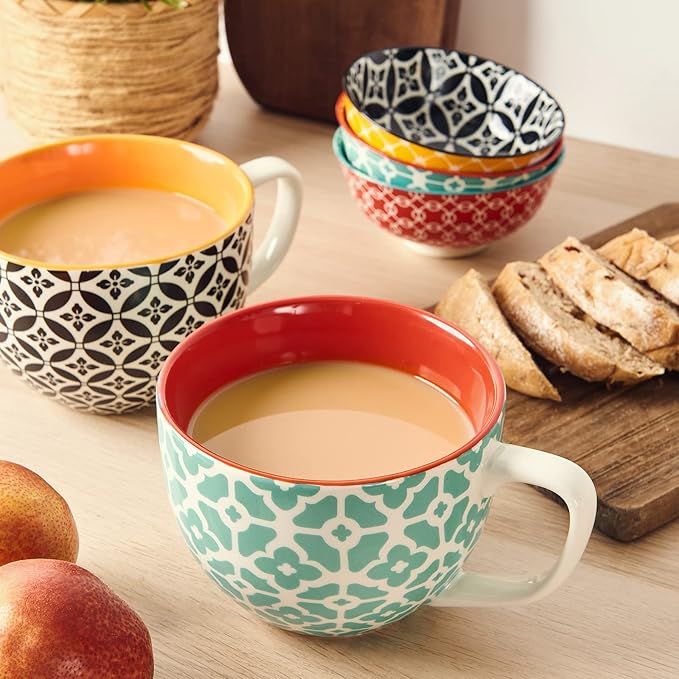 Ceramic coffee mugs on a wooden table: teal floral pattern and red interior, plus matching cups