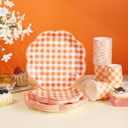 Orange and white gingham tableware set: stacked plates, cups, and cutlery