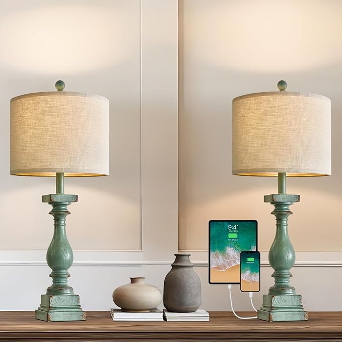 Pair of green table lamps with beige drum shades on tabletop
